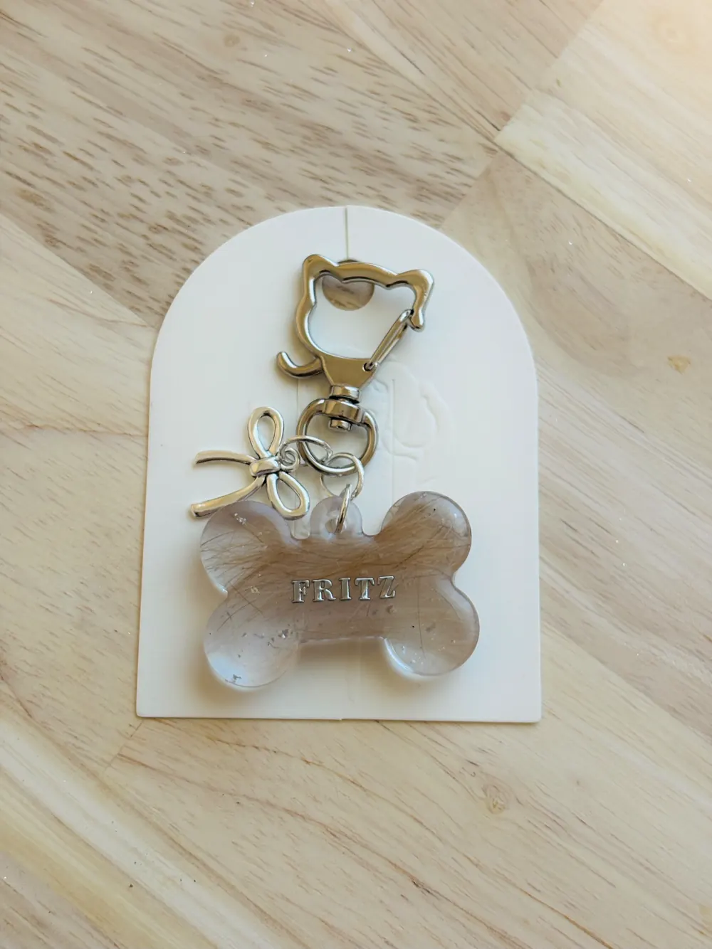 Bone-shaped resin pet keepsake containing a lock of Fritz's hair
